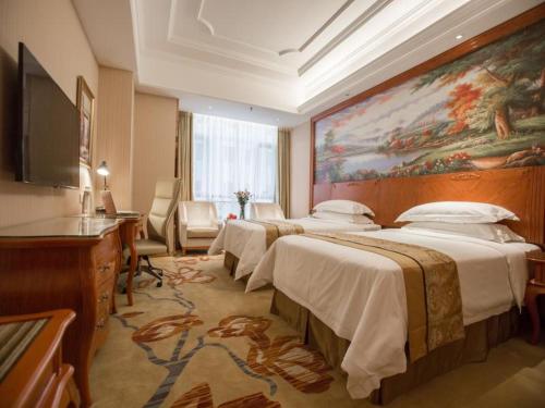 西安维也纳国际酒店西安汉城湖店的酒店客房带两张床和一幅大画