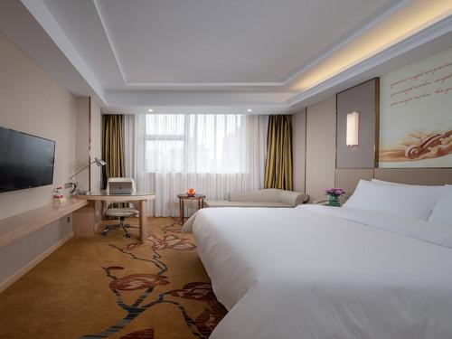 赣州维也纳酒店 (江西赣州火车站店)的酒店客房设有一张大床和一张书桌。