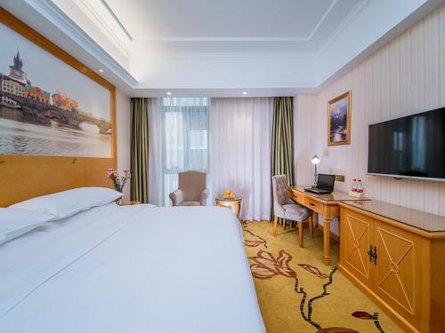 武汉维也纳酒店 (武汉兴业路石桥地铁站店)的酒店客房配有一张床和一张带电脑的书桌