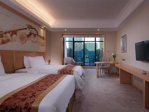 琼海维也纳酒店 (海南琼海嘉积银海路店)的酒店客房设有两张床和电视。