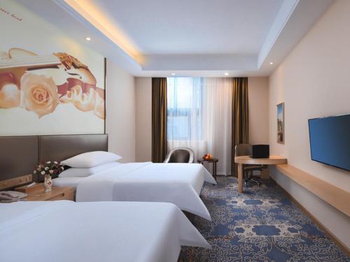 金山区维也纳酒店(上海金山卫火车站城市沙滩店)的酒店客房设有两张床和一台平面电视。