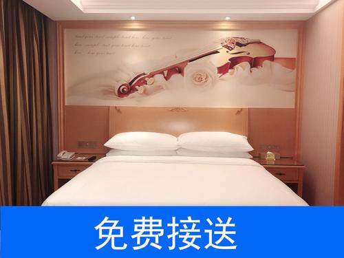 广州维也纳酒店广州番禺南站店的酒店客房的上方设有一张带标志的床