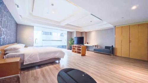 上海维也纳国际店上海虹口广粤路店的一间卧室配有一张床、一张书桌和一台电视