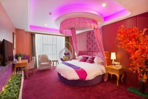 长沙维也纳国际酒店湖南长沙红星店的一间卧室设有一张大床,拥有紫色的天花板