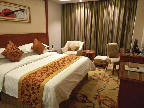 平凉维也纳智好酒店崆峒大道店的酒店客房带一张大床和一把椅子