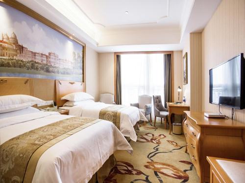 Yinzhan维也纳国际酒店贵州瓮安麒龙缤纷摩尔城店的酒店客房设有两张床和一台平面电视。