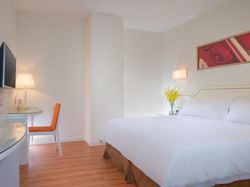 深圳维也纳三好酒店深圳沙嘴路店的卧室配有一张白色大床和一张书桌
