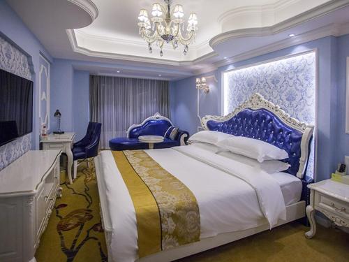 成都维也纳酒店成都大丰地铁站店的一间卧室配有一张大床和一个吊灯。