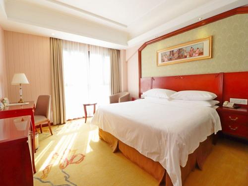 上海维也纳酒店上海虹桥国家会展纪翟路店的一间设有大床和窗户的酒店客房
