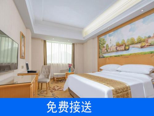 广州维也纳酒店广州番禺南站店的酒店客房设有一张大床和一张书桌。