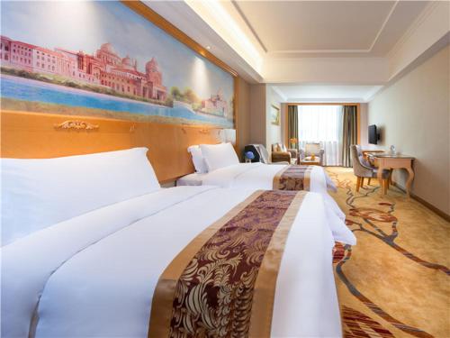 深圳维也纳国际酒店（深圳布吉大芬店）的酒店客房设有两张床,墙上挂有绘画作品