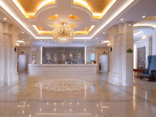 深圳维也纳国际酒店深圳大梅沙店的大型客房设有吊灯和大型大堂。