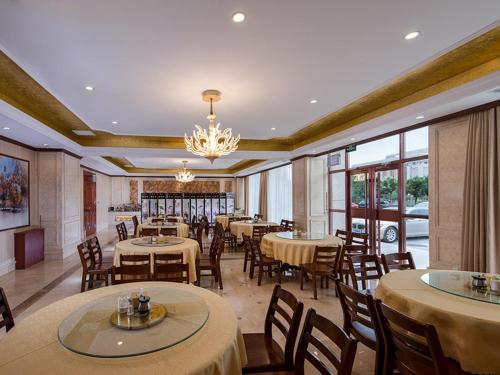阿拉善左旗维也纳国际酒店内蒙古阿拉善店的一间带桌椅和吊灯的餐厅