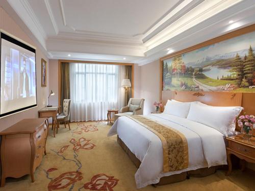 广州维也纳酒店广州天河客运站店的酒店客房设有一张大床和一张书桌。
