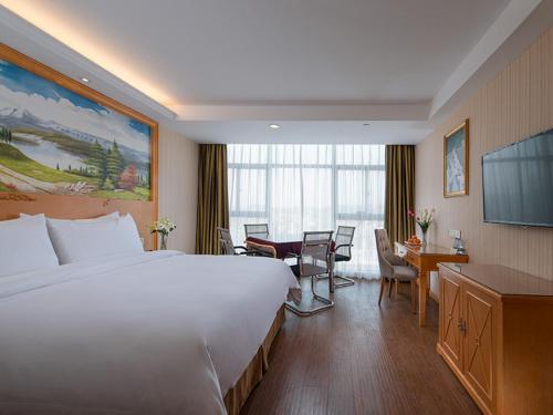 福州维也纳酒店 (福州长乐国际机场店)的酒店客房设有一张白色大床和一张书桌