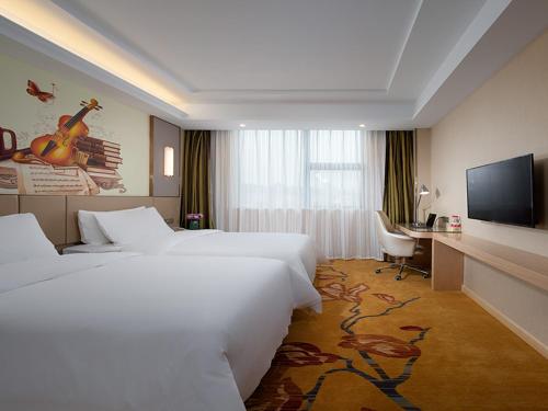 赣州维也纳酒店 (江西赣州火车站店)的酒店客房设有两张床和一台平面电视。
