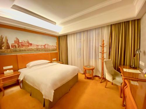 常德维也纳酒店湖南常德武陵大道店的酒店客房设有一张大床和一张书桌。