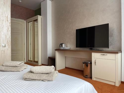 敖德萨Lustforlive的一间卧室配有带2条毛巾的床和平板电视