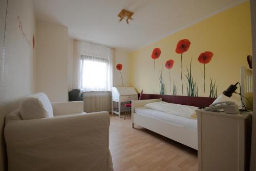 米赫拉克尔施费斯艾克酒店的客厅配有沙发,墙上挂着红色鲜花