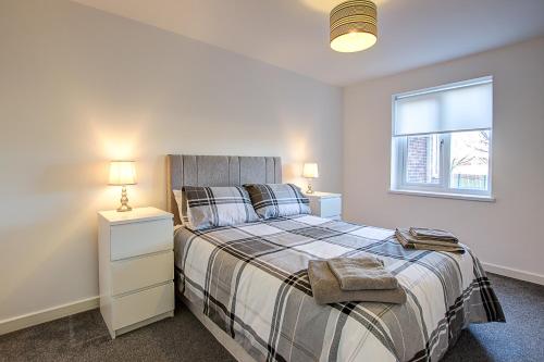 桑德兰Sunderland Short Stays 2 bedroom apartment Free Parking Fulwell SR6的一间卧室设有一张床和一个窗口