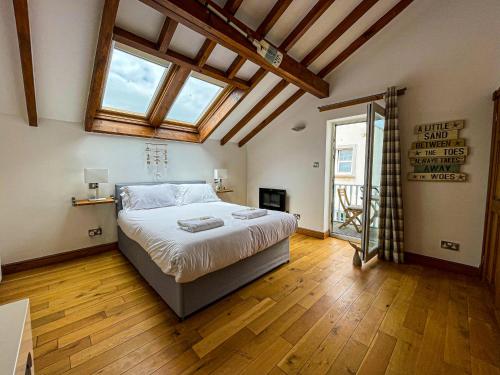 波特帕特里克Harbourside Apartments的卧室配有一张大床、木地板和窗户。