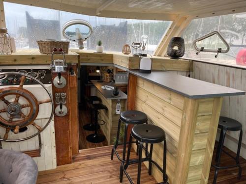 乌伊斯特勒昂Exceptionnel bateau maison reine mathilde的船上的厨房,带柜台和凳子