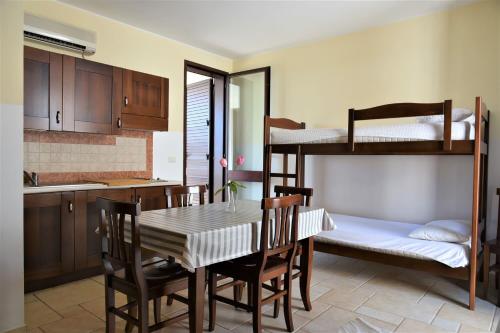 托里德欧索Residence Club Costa D'Oriente的厨房以及带桌子和双层床的用餐室。
