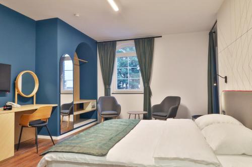 佩奇Benelux Hotel的酒店客房,配有一张床、一张桌子和椅子