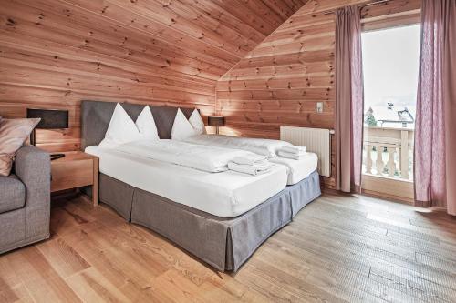 滨湖采尔Chalet Dacha mit finnischer Sauna的木制客房内的一间卧室配有一张大床
