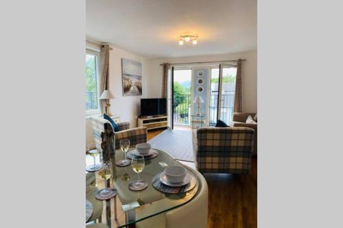 巴洛赫Riverside View Apartment in Balloch, Loch Lomond的客厅配有桌子和沙发