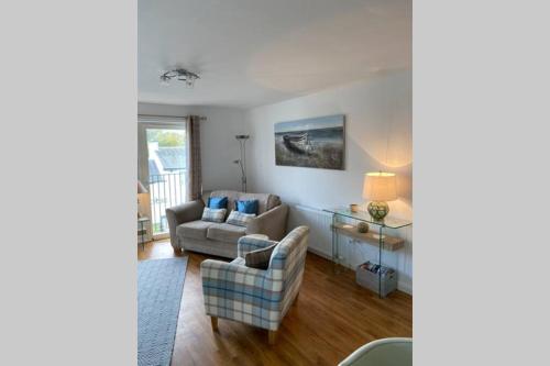 巴洛赫Riverside View Apartment in Balloch, Loch Lomond的客厅配有沙发和椅子