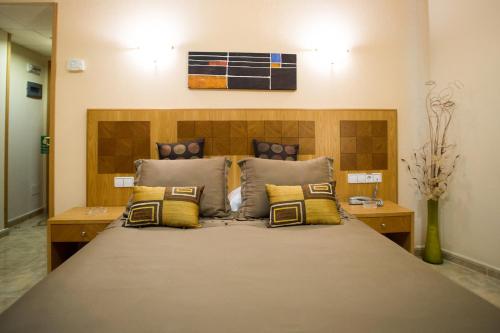 埃尔莫拉尔阿祖尔旅馆的一间卧室配有一张带黄色枕头的大床