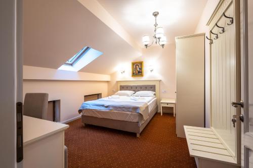 奥勒什蒂耶Apartament Hotel H的一间卧室配有一张床、一张书桌和一个窗户。