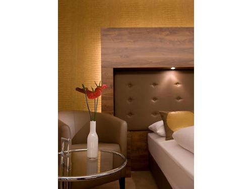 杜伊斯堡孔蒂杜伊斯堡酒店-索拉酒店的合作伙伴的一间设有床和玻璃桌及花瓶的房间