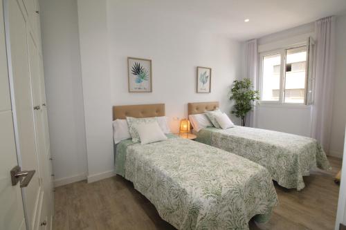 马拉加Del Parque Flats Puerto的一间卧室设有两张床和窗户。