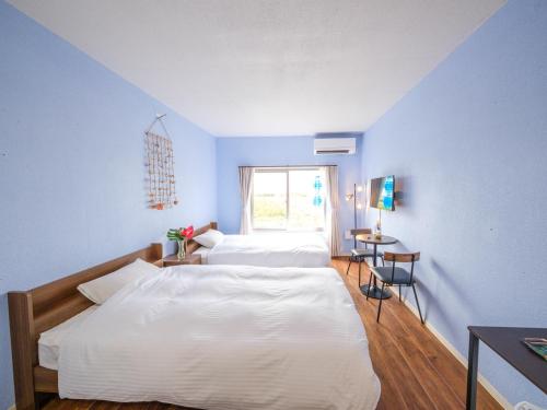 宫古岛Hotel Shion no Umi - Vacation STAY 98886的一间卧室设有两张床和窗户。