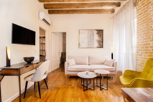 科孚镇Curcumelli Luxury Suites - ΚΟΡΚΥΡΑ的客厅配有沙发和桌子
