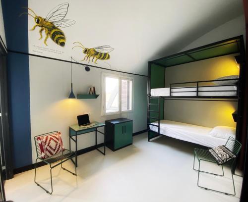 米兰YellowSquare Milan的一间卧室配有一张双层床、一张桌子和一张蜜蜂床。