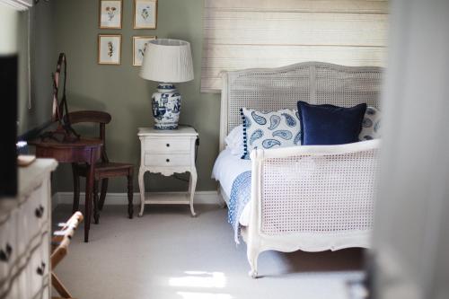 Barford Saint MichaelThe George Inn的一间卧室配有一张床和一张带台灯的桌子