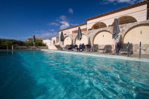 卢米奥海宁别墅酒店的一座带椅子和遮阳伞的游泳池位于一座建筑旁边