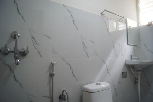 迈索尔Cornerbunker的白色的浴室设有卫生间和水槽。