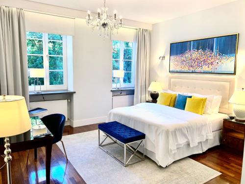 华沙MONDRIAN Luxury Suites UNESCO Old Town的卧室配有一张白色大床和吊灯。