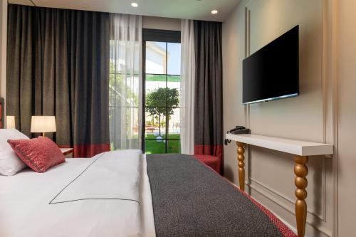 切什梅Motif Hotel Çeşme的配有一张床和一台平面电视的酒店客房