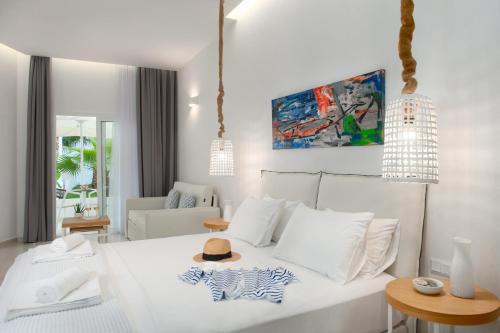 卡尼奥提Lefko Suites的卧室配有白色的床和帽子