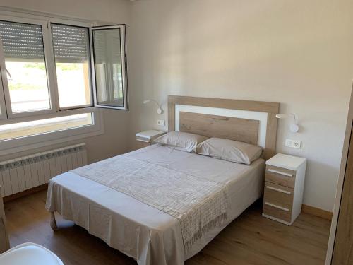 MaestuTellazar的卧室配有一张白色大床和两个窗户