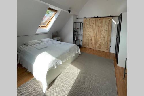 扎科帕内Fresh Cosy Flat In Zakopane Center的卧室配有白色的床和推拉门。