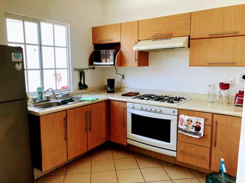 新巴利亚塔Casa Hestía的厨房配有木制橱柜和白色炉灶烤箱。