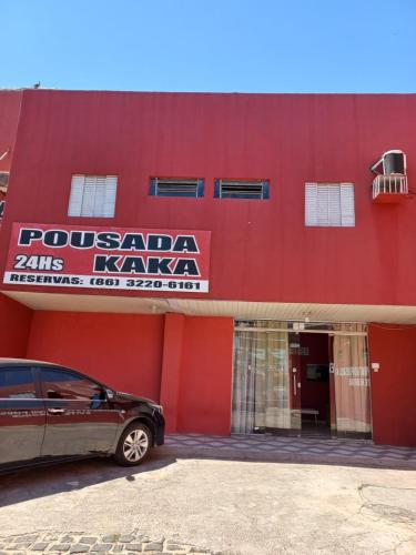 特雷西纳Pousada Kaka的前面有一辆汽车停在红色的建筑