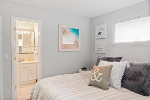 海洋海滩Vacationer's Dream By the Sea的一间白色卧室,配有床和一间浴室