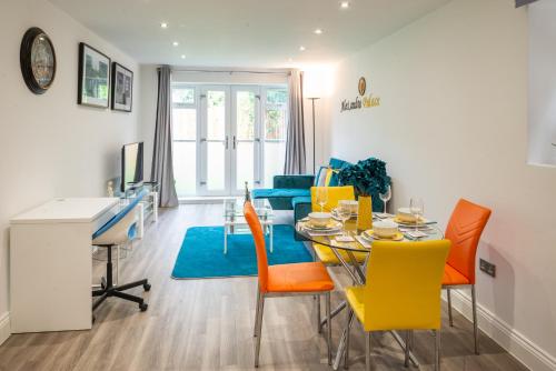 哈特菲尔德The 'Pinky' - Beautiful 1 Bed Apartment in Hatfield - FREE Parking - Near Uni & Business Park - Long stays - Corporate, Leisure, Contractors的用餐室以及带桌椅的起居室。